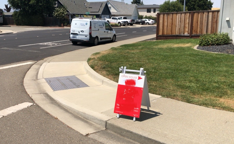 real estate sign in sidewalk