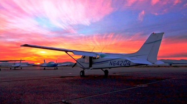 Three Airplanes Parked in Front of a Sunset